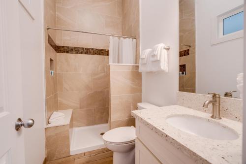 a bathroom with a toilet and a sink and a shower at Unit 5 Maui Ohana Modern Studio in Wailuku