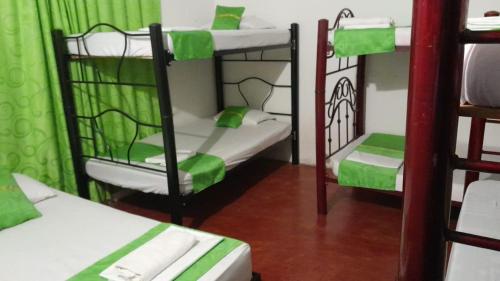 a room with two bunk beds and green curtains at LUNA del DESIERTO TATACOA in Villavieja