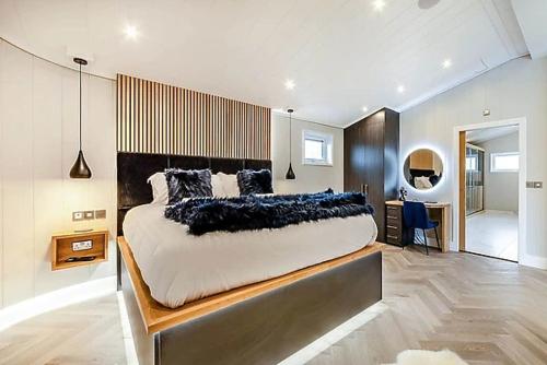 1 dormitorio con 1 cama grande y escritorio en Luxury 5 Star London Lodge - Parking, Garden, Hot Tub, near Metro Stations, en Wallington