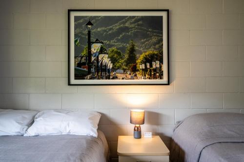 uma imagem pendurada numa parede ao lado de duas camas em Dawsons Hotel em Reefton