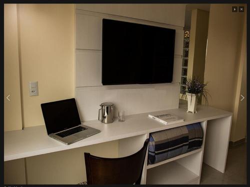 a desk with a laptop and a television on it at Hotel Sollievo in Irati