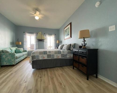 a blue bedroom with a bed and a couch at Beach House with Ocean view in Surfside Beach