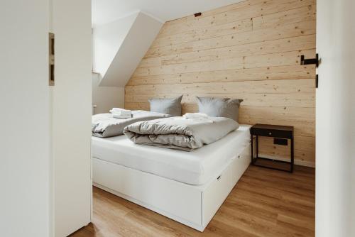 2 Betten in einem Zimmer mit einer Holzwand in der Unterkunft Harzchalet an der Brockenbahn 2B in Elend