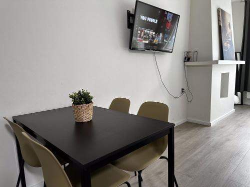 a black table with chairs and a tv on a wall at Hidden Gem next to TU Delft Campus Family XL house in Delft