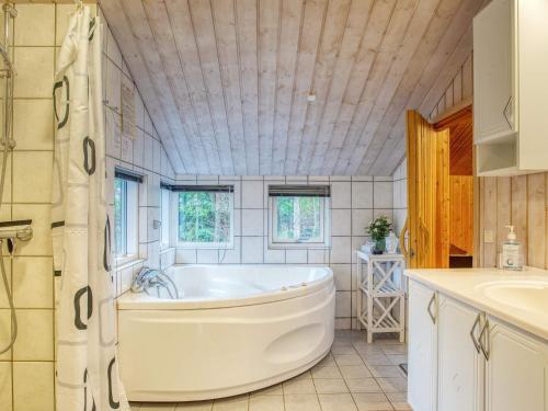 y baño con bañera y lavamanos. en Four-Bedroom Holiday home in Fjerritslev 10 en Torup Strand
