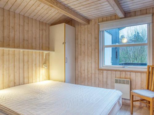 1 dormitorio con cama y ventana en Four-Bedroom Holiday home in Fjerritslev 10 en Torup Strand