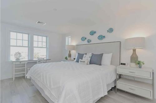 ein weißes Schlafzimmer mit einem großen weißen Bett und einem Schreibtisch in der Unterkunft Harbourtown Suite Water View in Plymouth