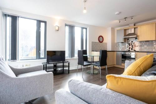 a living room with two couches and a kitchen at 2 Bed Flat Near Deansgate in Manchester