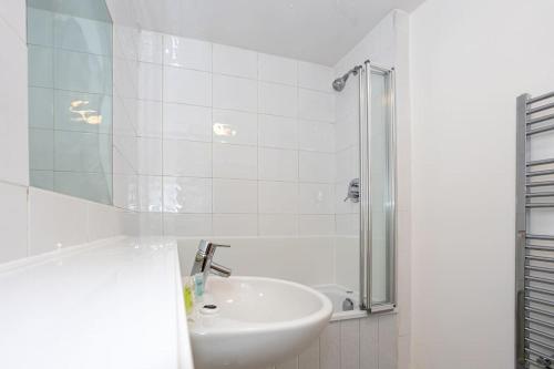 a white bathroom with a sink and a shower at 2 Bed Flat Near Deansgate in Manchester