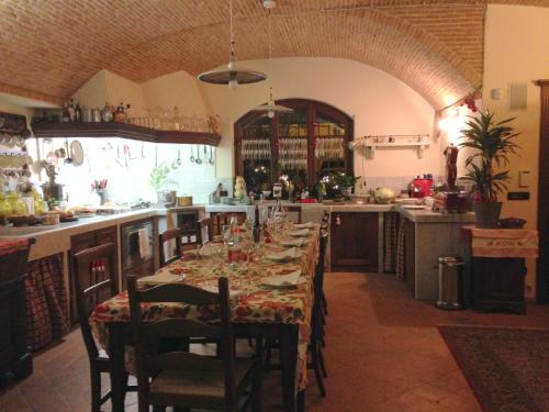 a kitchen with a long table with chairs and a tableablish at Agriturismo del Pigato - Bio Vio in Albenga