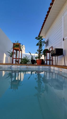 uma piscina em frente a uma casa com duas cadeiras em A Casinha de Madeira em Balneário Gaivotas