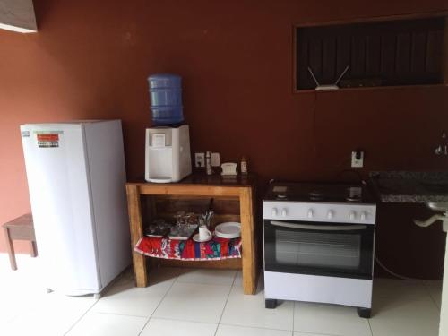 una cucina con piano cottura bianco e frigorifero di Pousada Raízes Guaramiranga a Guaramiranga
