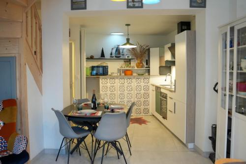 une cuisine et une salle à manger avec une table et des chaises dans l'établissement Maison vue Baie au coeur du quartier de l'Abbaye, à Saint-Valery-sur-Somme