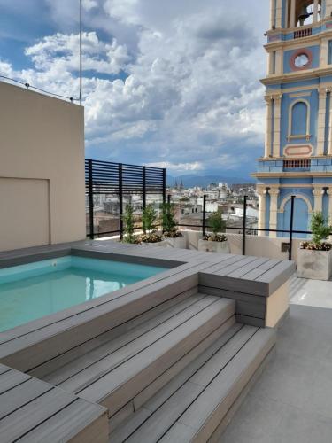 a pool on the roof of a building with a clock tower at Departamento Mirador de la Viña - centro de Salta Argentina in Salta