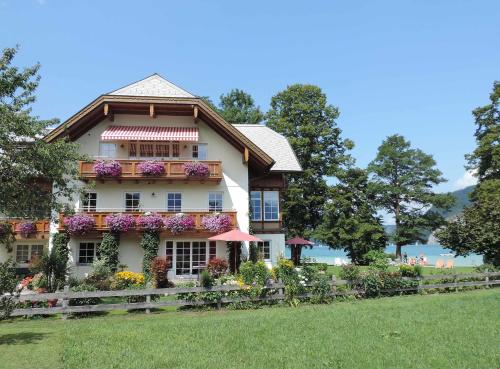 a house with flowers on the side of it at Landhaus Leitner am Wolfgangsee in Sankt Gilgen