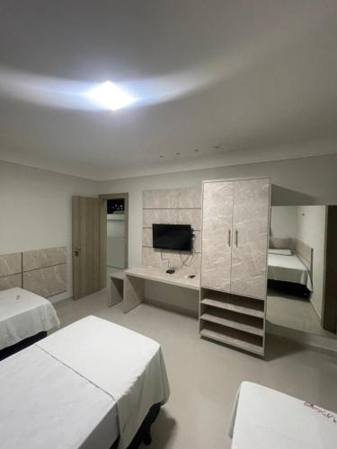 um quarto de hotel com duas camas e uma televisão em Mustang Hotel em Salgueiro
