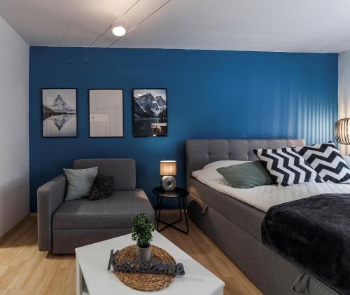 een slaapkamer met een bed, een bank en een stoel bij DEHOME - Laguna - Stay by Central Station in Koblenz