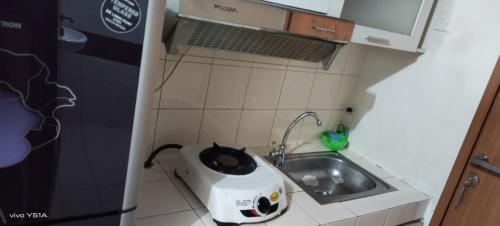 uma pequena cozinha com uma torradeira e um lavatório em MARGONDA RESIDENCE 3 em Kemirimuka Dua