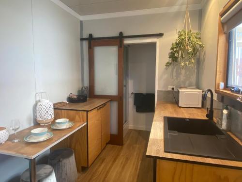 Cape Paterson的住宿－Beautiful tiny house with outdoor area- Only 5 minute walk to the beach!，厨房配有水槽和台面