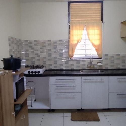 a kitchen with a sink and a window at 3 Bed House - Sleeps 4 - Parking - Enclosed Garden in Paramaribo