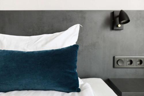 a bed with a blue and white pillow on it at Best Western Plaza Hotel in Eskilstuna