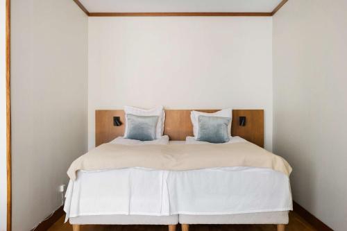 a bedroom with a white bed with blue pillows at Best Western Plaza Hotel in Eskilstuna
