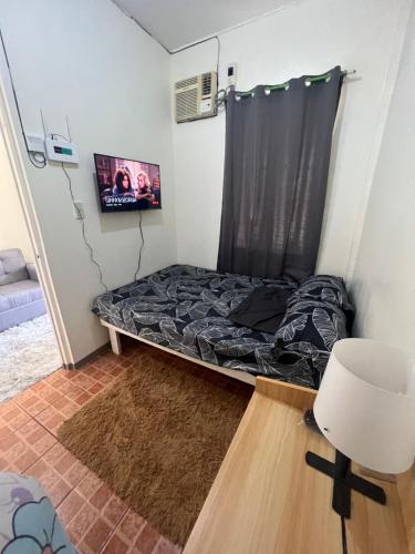 a small room with a bed and a chair at Yna's Place- The Third House in Lipa