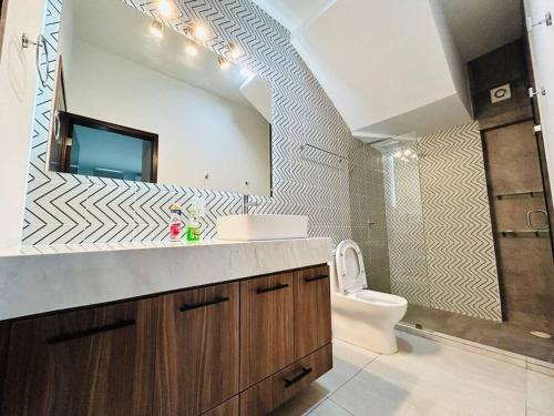 een badkamer met een wastafel, een toilet en een spiegel bij Estrella del mar · Hermosa casa vacacional in Barrón