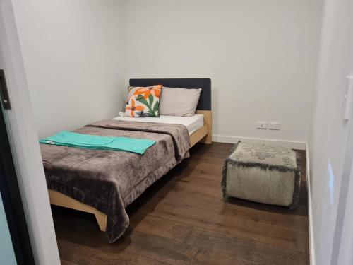 una piccola camera con letto e ottomana di Two Bedroom Apartment in North Melbourne a Melbourne