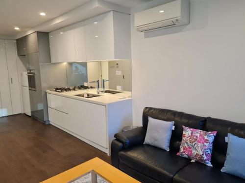 un soggiorno con divano e una cucina di Two Bedroom Apartment in North Melbourne a Melbourne