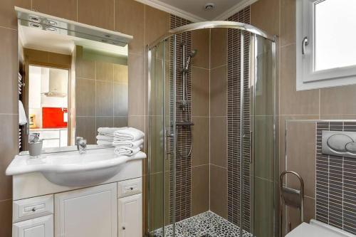 y baño con lavabo y ducha acristalada. en Studio Duplex - Le Garden - 10 mn Disney en Bailly-Romainvilliers