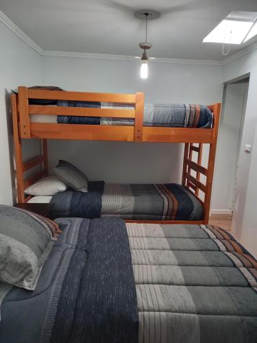 two bunk beds in a room with a bed at Cabañas y Departamentos Las Palmas, Temuco Depto 3 in Temuco