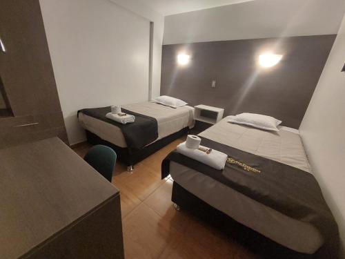 Cette chambre comprend deux lits et un bureau. dans l'établissement HOTEL SAN FRANCISCO - Moquegua, à Moquegua