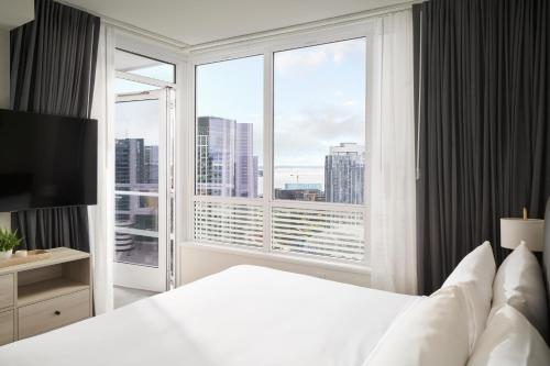 a bedroom with a white bed and a large window at Level Seattle Downtown - South Lake Union in Seattle