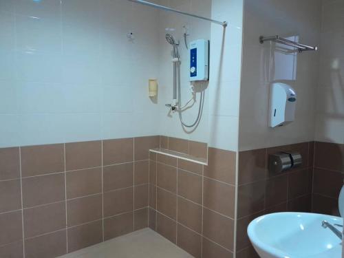 uma casa de banho com um chuveiro e um lavatório. em Reintree Lodge Hotel em Ipoh