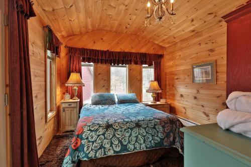 Un dormitorio con una cama en una cabaña de madera. en The Tanglewood Lodge- Amazing Ski Home for Groups, Hot Tub, Close to Killington Resort! home, en Killington