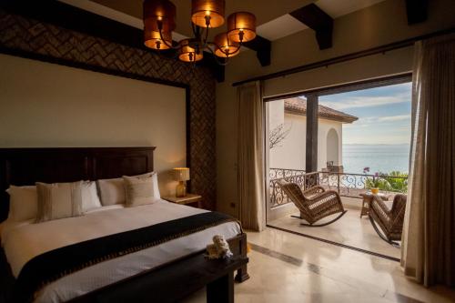 a bedroom with a large bed and a large window at Orchid House Baja in La Paz