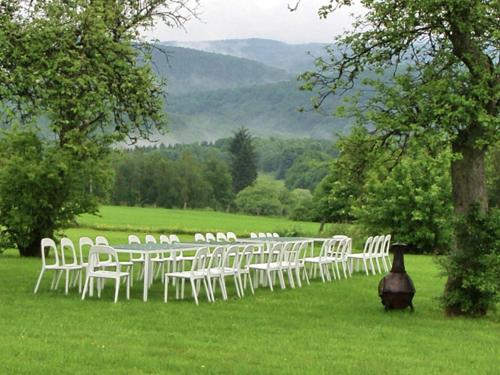 a group of white chairs sitting in the grass at Mountain Retreat for Group in Daverdisse