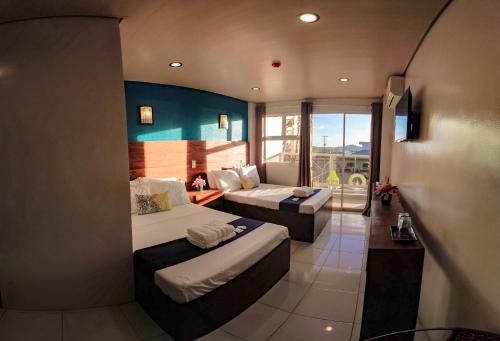 a hotel room with two beds and a balcony at A&A ABE BAYFRONT INN in Coron
