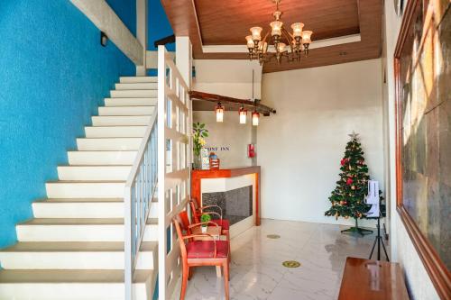 a staircase in a living room with a christmas tree at A&A ABE BAYFRONT INN in Coron