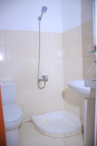 a white bathroom with a toilet and a sink at ALShawarbi Plaza Hotel in Cairo