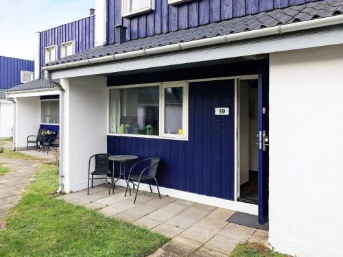 a blue front door of a house with a table and chairs at 4 person holiday home in Væggerløse-By Traum in Bøtø By