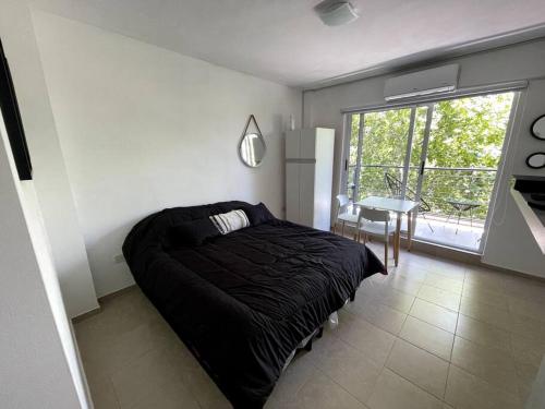 1 dormitorio con cama, mesa y ventana en Agradable monoambiente en Urquiza- Incas1 en Buenos Aires