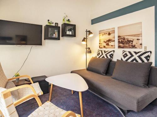 a living room with a couch and a table at 4 person holiday home in Væggerløse-By Traum in Bøtø By