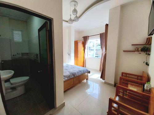 a bedroom with a bed and a bathroom with a sink at Cam Ly Homestay in Da Lat