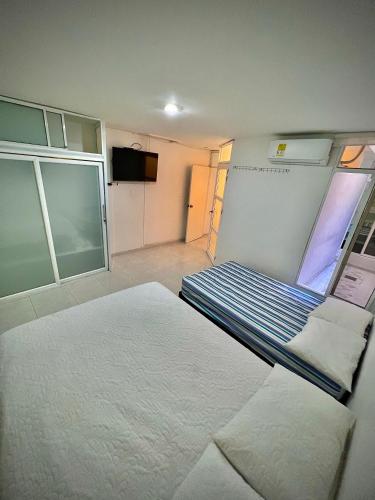 バジェドゥパルにあるAcogedor apartamento amoblado con parqueaderoのベッド1台とテレビが備わる小さな客室です。