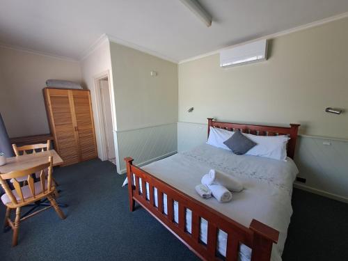 a bedroom with a bed with towels on it at Great Western Motel in Great Western