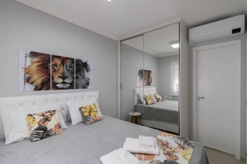 a bedroom with a king sized bed and a mirror at Family Apartment - GRU in Guarulhos