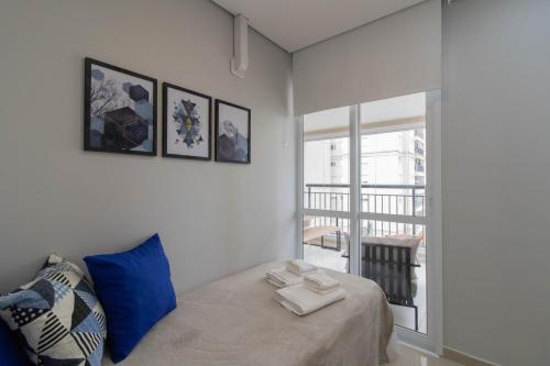 a bedroom with a bed with a blue pillow and a window at Family Apartment - GRU in Guarulhos