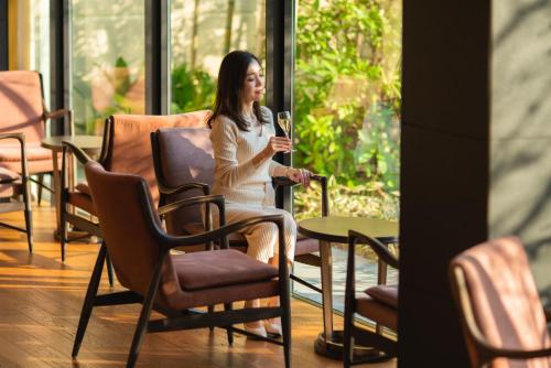 a woman sitting at a table with a glass of wine at The Hotel Seiryu Kyoto Kiyomizu - a member of the Leading Hotels of the World- in Kyoto